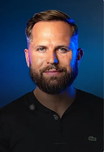 Portrait of a man in a black polo showing high-density hair transplant results