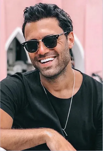Smiling man with full hair and sunglasses after hair restoration