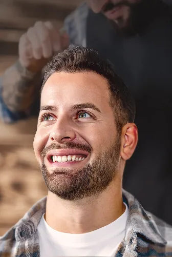 Smiling man showcasing successful hair transplant results